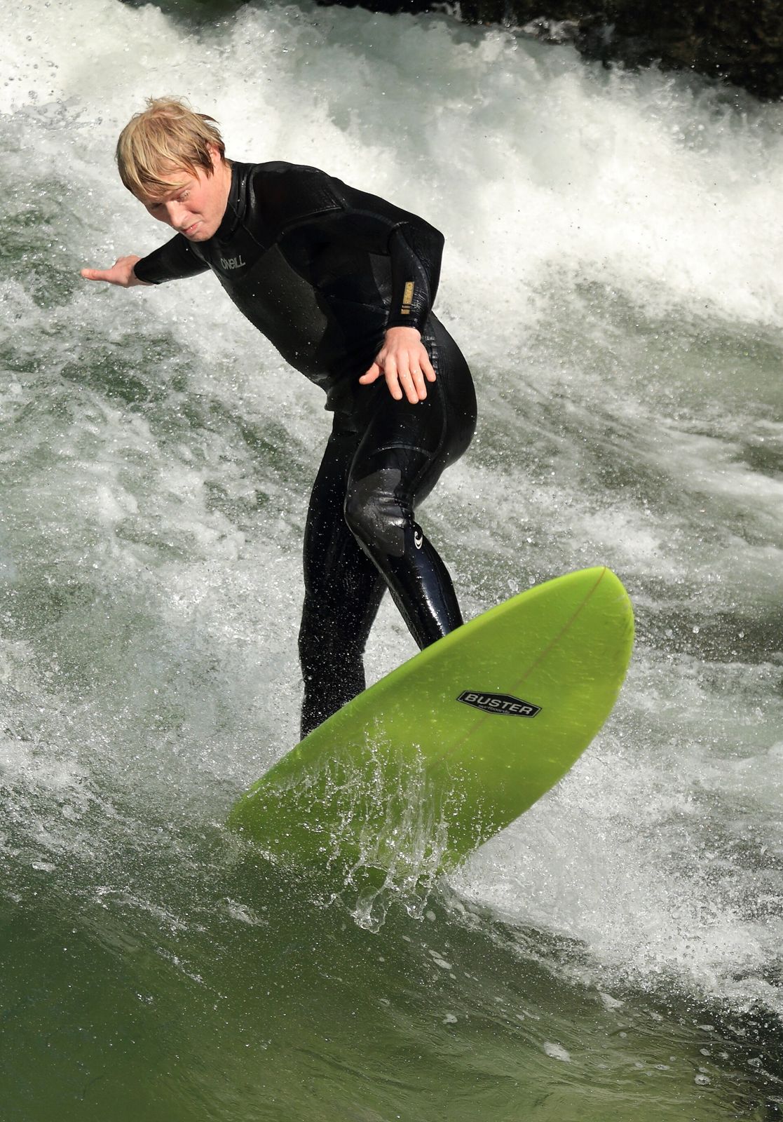 Surfer riding the Eisbach wave in Munich's English Garden