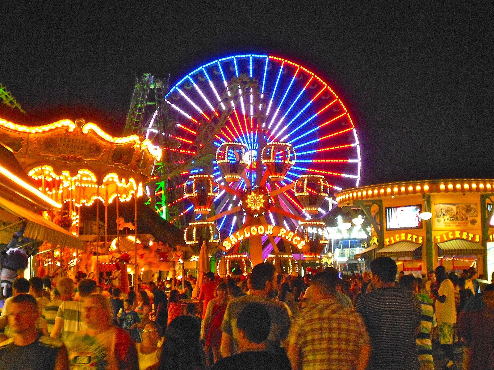 Ferris wheel on a boardwalk pier at night